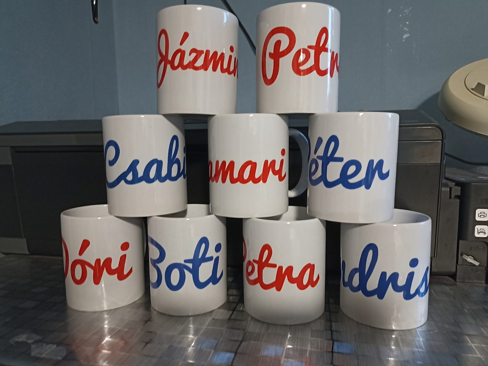 Névfeliratú bögrék sorozata piros-kék kurzív betűkkel